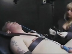 Bondaged dude with lip clamps endures his cock and balls roped and pulled tight
